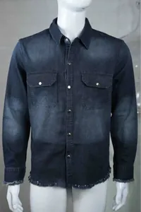 Close-up of men's washed denim shirt showing snap buttons and raw edge details