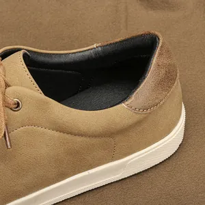 Primer plano de zapatillas de ante marrón para hombre con ribete de cuero y costuras