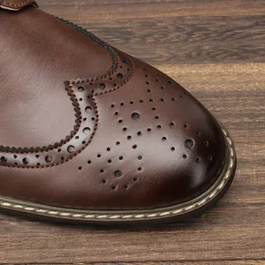 Gros plan de chaussures Brogue en cuir marron avec perforations et coutures wingtip.