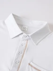 Gros plan du col d'un polo blanc pour hommes avec boutons et surpiqûres brunes