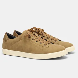 Vista lateral de zapatillas informales de ante marrón para hombre con suelas blancas