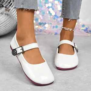 Detailed view of white patent leather Mary Jane flats featuring a vintage rose metal buckle.