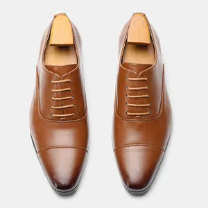 Top view of classic men's brown leather Oxford shoes with wooden shoe trees