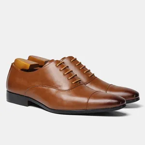 Detailed view of high-quality brown leather men's Oxford shoes with a classic cap-toe finish