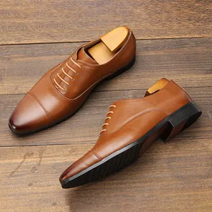 Premium brown leather Oxford business shoes displayed on a rustic wooden floor with shoe trees