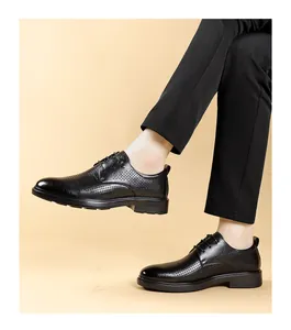 Detail view of black perforated leather business shoes worn with elegant black trousers