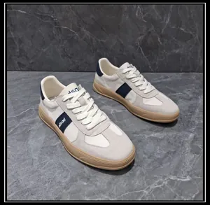 Detailed view of men's leather and fabric GAT sneakers with navy stripe and gum sole.