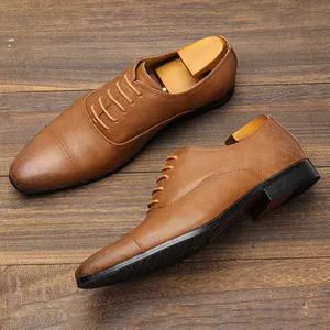 Detailed view of high-quality tan leather Oxford shoes for men on a rustic wooden background