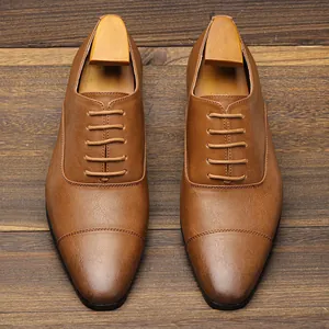 Overhead view of classic tan men's business Oxford shoes on wooden floor texture