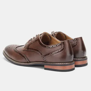 Vue détaillée des chaussures Brogue marron avec des motifs de perforation complexes.