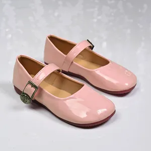 Close-up of pink patent leather Mary Jane flats with decorative floral buckle detail