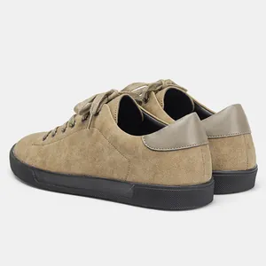 Vista posterior detallada de zapatillas de gamuza caqui para hombre con suelas planas negras