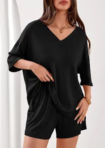 Dettaglio ravvicinato della trama del tessuto a coste nero su un set casual da donna con scollo a V