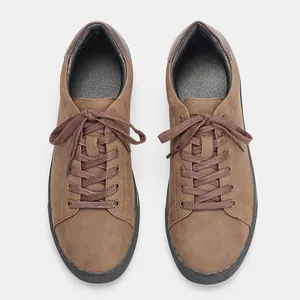 Vista superior de zapatos casuales marrones para hombre con suelas negras y cordones