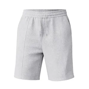 Détail rapproché de short en maille gaufrée grise avec cordon et poches