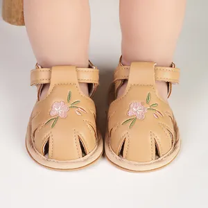 Macro view of baby girl sandals featuring delicate pink flower embroidery details