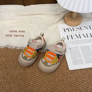 Vista dettagliata delle sneakers sportive traspiranti per bambini con lacci arancioni