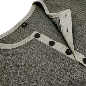 Close-up macro view of a men's green ribbed Henley shirt showing buttons and collar