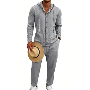 Inquadratura di un uomo con camicia in lino grigio con cappuccio e pantaloni coordinati