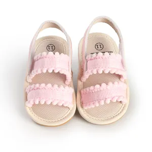 Detailed view of pink infant walking sandals with pom-pom trim and size 11 insoles.