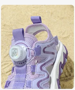 Close-up of purple kids sporty beach sandals featuring a unique dial lacing system on sand.
