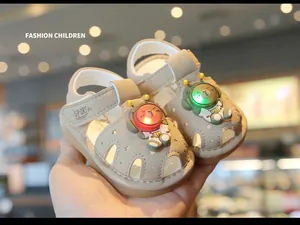 Close-up of beige toddler light-up sandals featuring cute cartoon space bear decorations