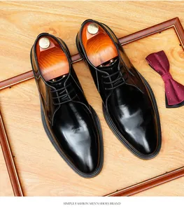 High-shine black leather business shoes with elegant red bow tie in wooden frame