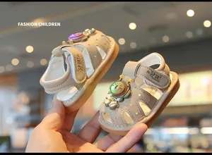 Close-up of beige baby sandals with light-up astronaut decor and star cutouts