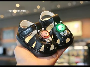 Detailed macro view of black toddler sandals featuring glowing cartoon bear designs