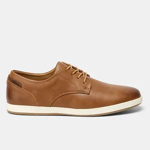 Perfil lateral de zapatos casuales de cuero marrón para hombre con cordones y suela blanca.