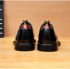 Rear view of elegant black leather dress shoes with wooden shoe trees on a wooden floor