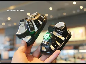 Detail of black light-up baby sandals with cute astronaut bear decoration.