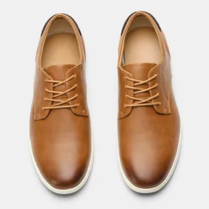 Vista superior de zapatos Oxford de hombre en cuero marrón con cordones y suela blanca