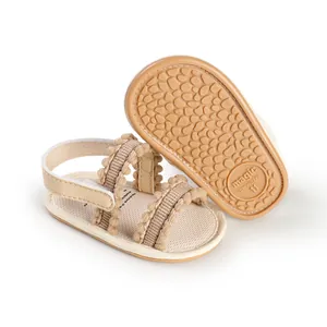Detail of breathable beige baby pre-walker sandals with non-slip rubber sole.
