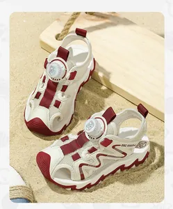 Close-up detail of off-white children's sports sandals with maroon accents and rotary buckle