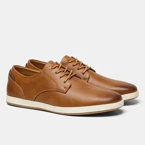 Detalle de zapatos casuales de cuero marrón para hombre con suela de goma blanca