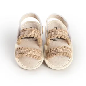 Top down view of beige infant walking sandals featuring cute pom-pom trim details