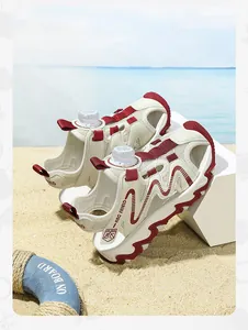 Close-up detail of children's beige and red closed-toe sports sandals on a sunny beach