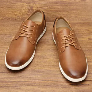 Vista superior de zapatillas casuales de cuero marrón para hombre sobre madera