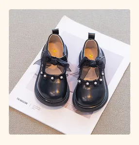 Vista detallada de zapatos de princesa negros para niña con lazos de encaje y detalles de perlas