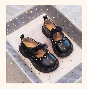 Vista detallada de zapatos de princesa Mary Jane negros para niñas con lazo y perlas