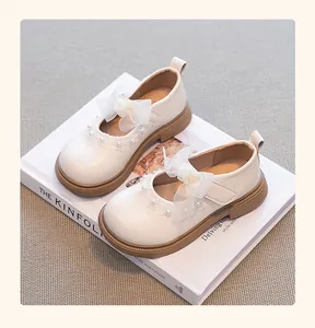 Vista detallada de elegantes zapatos de princesa blancos para niñas con un lazo.