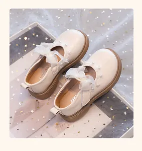 Vista superior de zapatos Mary Jane blancos para niñas con lazos y detalles de perlas.