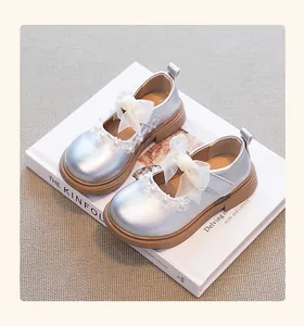 Primer plano detallado de zapatos de princesa para niñas plateados con lazo y detalles de encaje