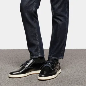 Primer plano de zapatos informales de cuero negro para hombre con vaqueros oscuros