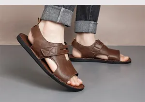 Sandali da uomo in ecopelle marrone con velcro, mostrati ai piedi in un set fotografico