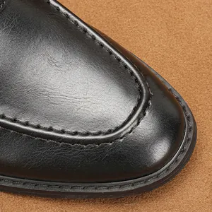 Nahaufnahme der Spitze eines schwarzen Leder-Loafers mit detaillierten Nähten.