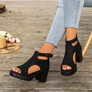 Detailed view of black chunky high heel sandals with laser-cut hollow patterns and peep toe.