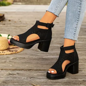 Close-up of black women's chunky high heel sandals featuring elegant laser-cut floral patterns