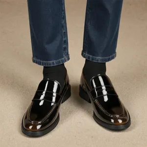 Nahaufnahme von polierten Herren-Penny-Loafers mit Jeans und Socken